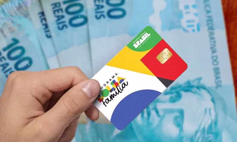Cartão do programa Bolsa Família em frente a notas de R$100, simbolizando as mudanças e exclusões recentes no programa.