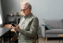 Idoso usando smartphone em casa para acessar aplicativos do dia a dia