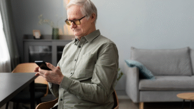 Idoso usando smartphone em casa para acessar aplicativos do dia a dia
