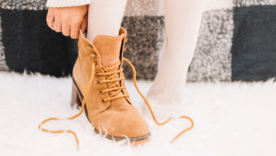 Bota de camurça caramelo com cadarço sendo calçada com meias claras