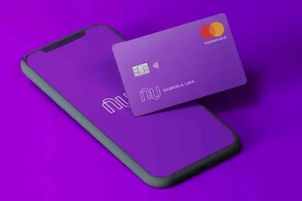 Imagem do cartão Nubank roxo com tecnologia de pagamento por aproximação, ao lado de um celular com o logo da empresa visível.