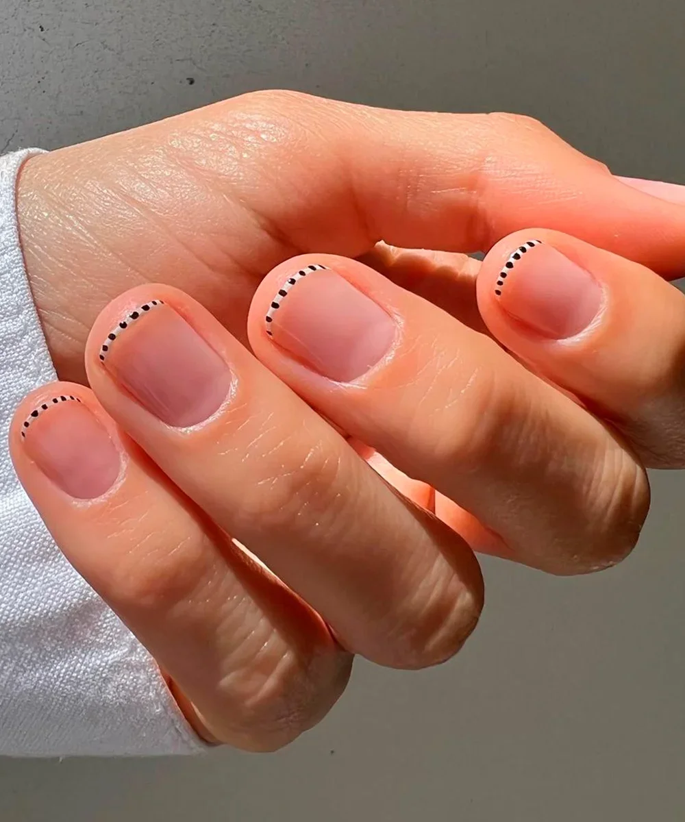 Unhas francesinha reinventada com pontinhos pretos na ponta, estilo minimalista e moderno