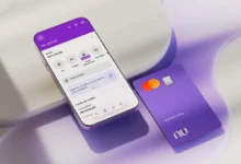 Imagem do aplicativo Nubank aberto em um celular com o cartão Nubank roxo ao lado, mostrando informações da conta do usuário.