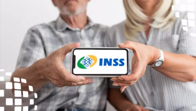 Casal de idosos exibe celular com logotipo do INSS, representando adesão ao ressarcimento