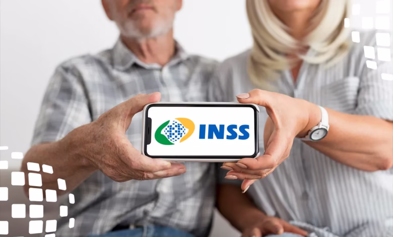 Casal de idosos exibe celular com logotipo do INSS, representando adesão ao ressarcimento