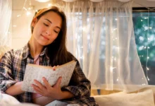 Mulher lendo um livro em um ambiente acolhedor com luzes suaves ao fundo, refletindo a calma e o relaxamento antes de dormir.