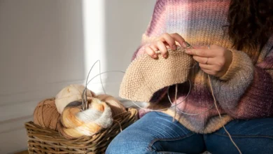 Mulher tricotando em um ambiente aconchegante, com foco no trabalho manual como terapia para o bem-estar.