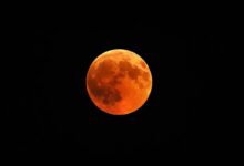 Lua do Veado com tom avermelhado no céu noturno.