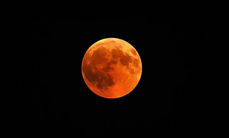 Lua do Veado com tom avermelhado no céu noturno.