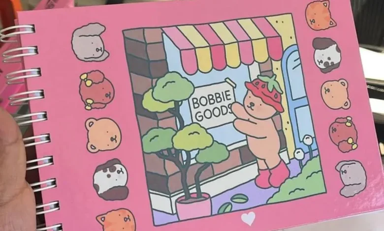 Desenho fofo de um ursinho vestido de morango em frente à loja Bobbie Goods, com personagens de animais ao redor