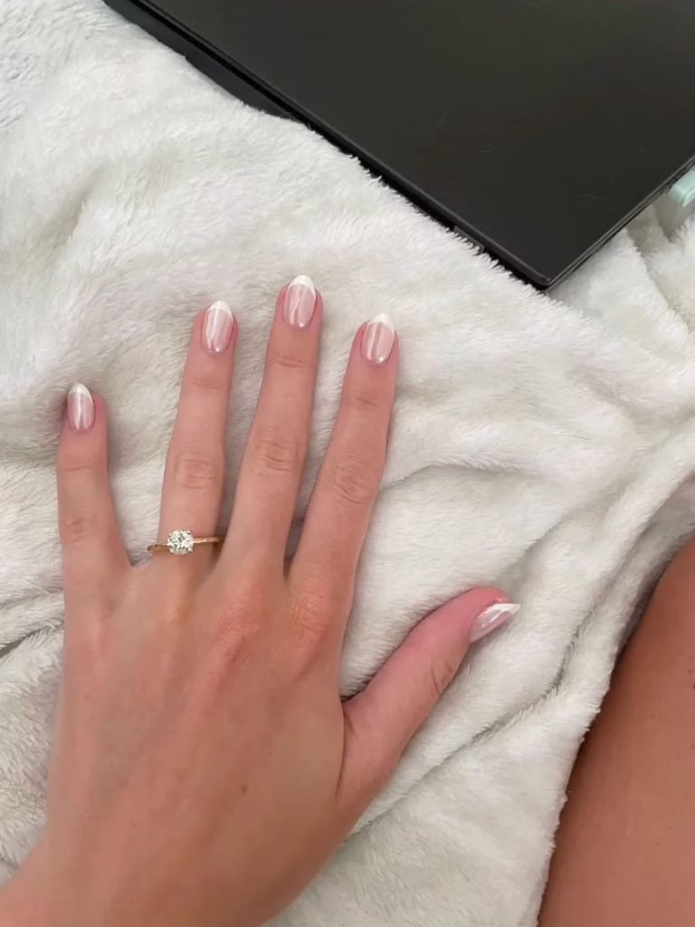 Unhas brancas minimalistas com detalhes geométricos em linha diagonal, estilo moderno e elegante.