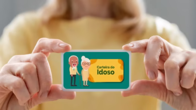 Pessoa segurando uma Carteira do Idoso com ilustração colorida.