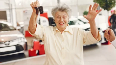 Mulher sorridente segurando as chaves de um carro novo na melhor idade.