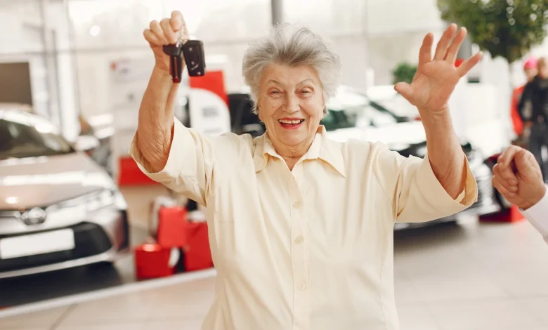 Mulher sorridente segurando as chaves de um carro novo na melhor idade.