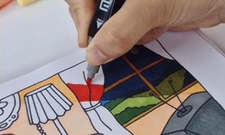 Técnica para colorir páginas Bobbie Goods sem manchar, mostrando uma mão usando marcador em uma ilustração detalhada.