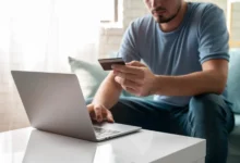 Homem usando cartão de crédito para realizar compras online com segurança.
