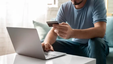 Homem usando cartão de crédito para realizar compras online com segurança.