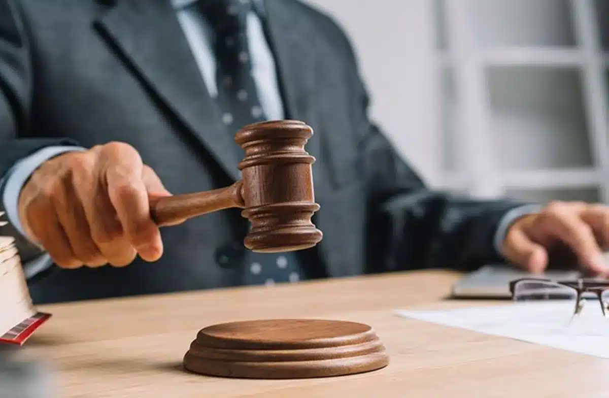 Juiz em um tribunal realizando a concessão de decisão com o uso de um martelo, representando a cessão de crédito judicial.