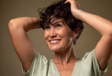 Mulher madura sorrindo após corte de cabelo moderno, destacando um estilo rejuvenescente e elegante.