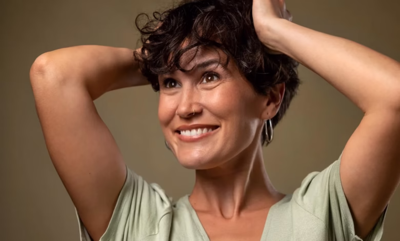 Mulher madura sorrindo após corte de cabelo moderno, destacando um estilo rejuvenescente e elegante.