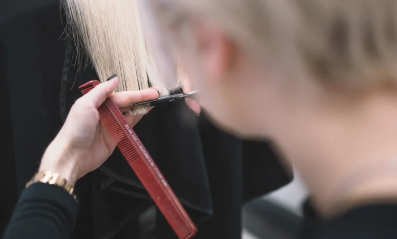 Cabeleireiro realizando um corte de cabelo em um cliente com fios brancos, rejuvenescendo o visual.