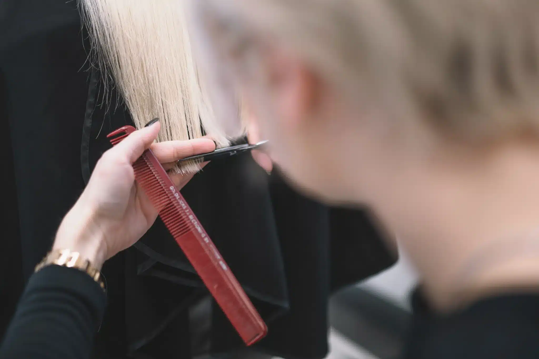 Cabeleireiro realizando um corte de cabelo em um cliente com fios brancos, rejuvenescendo o visual.