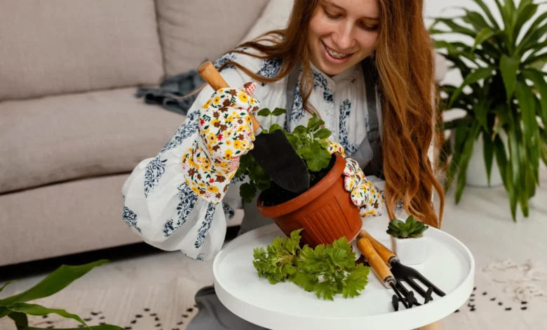 Mulher sorridente plantando em casa com ferramentas de jardinagem e vaso de planta em um ambiente aconchegante.