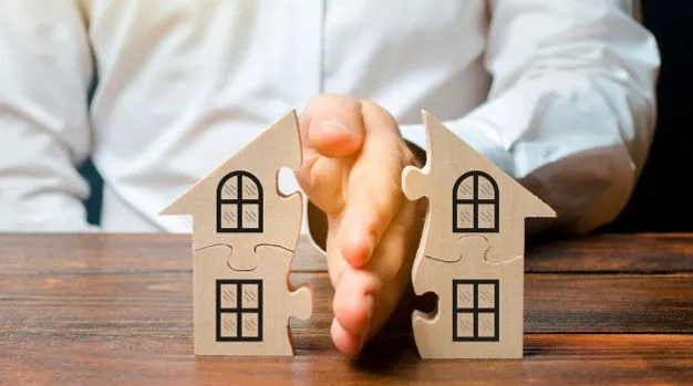 Divisão de bens após o falecimento, representada por duas casas de quebra-cabeça se separando.