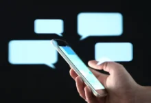 Pessoa segurando celular enquanto envia mensagem de texto carinhosa à noite.