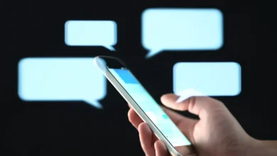 Pessoa segurando celular enquanto envia mensagem de texto carinhosa à noite.
