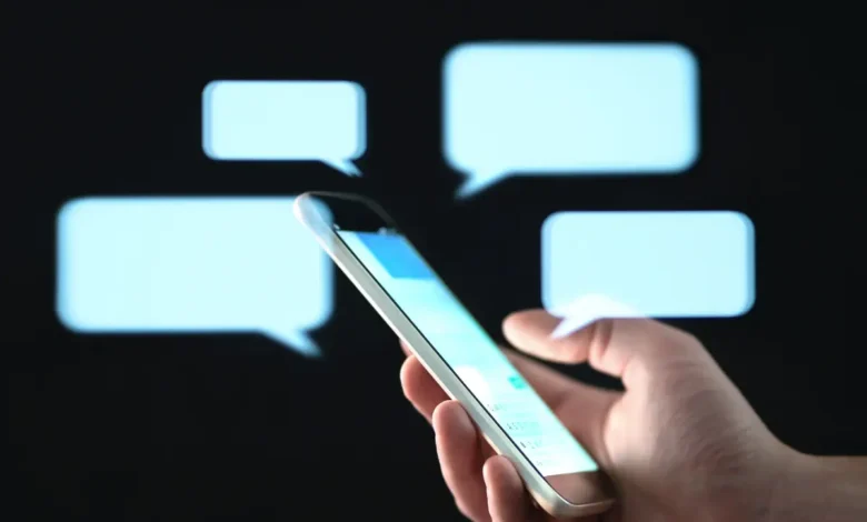 Pessoa segurando celular enquanto envia mensagem de texto carinhosa à noite.