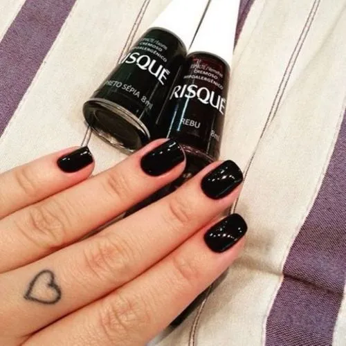 Unhas com esmalte escuro aplicado corretamente sem manchas.