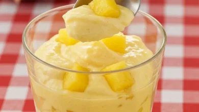 Gelado de abacaxi com creme em copo transparente com pedaços de abacaxi fresco