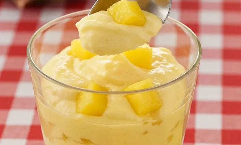 Gelado de abacaxi com creme em copo transparente com pedaços de abacaxi fresco