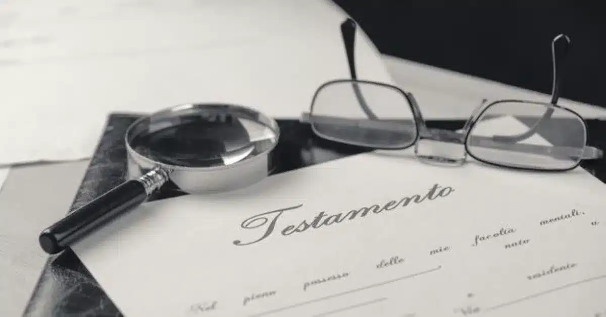 Documento de testamento com lupa e óculos, simbolizando a análise de herança.