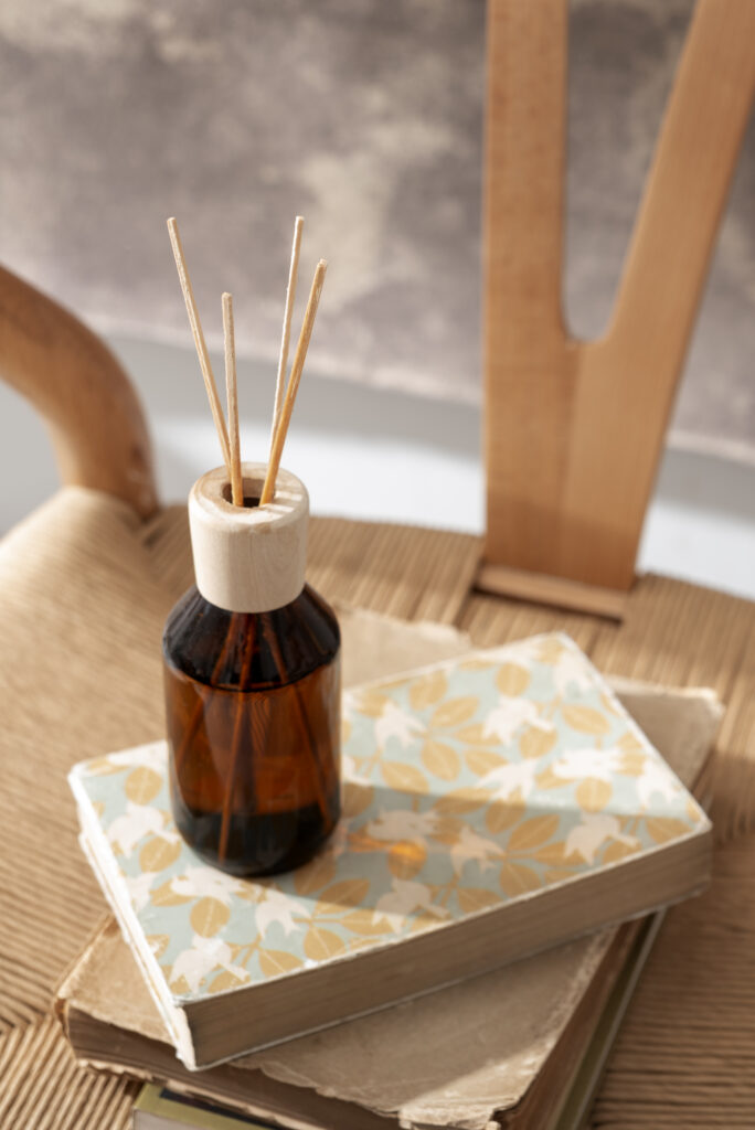 Difusor de aromas em frasco âmbar sobre livros decorativos