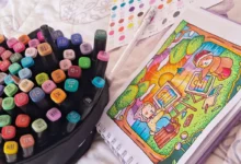 Kit de marcadores coloridos ao lado de um desenho Bobbie Goods colorido com ursinhos pintando ao pôr do sol.