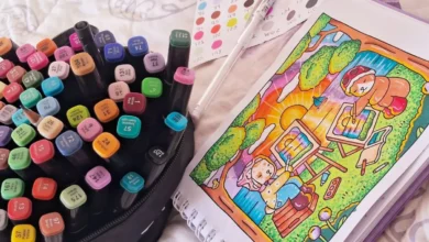 Kit de marcadores coloridos ao lado de um desenho Bobbie Goods colorido com ursinhos pintando ao pôr do sol.