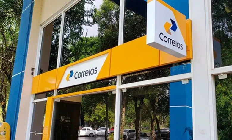 Fachada da agência dos Correios, com o logotipo visível e elementos de branding em azul e amarelo.