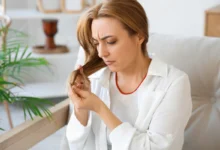 Mulher analisando pontas ressecadas em cabelo fino e danificado