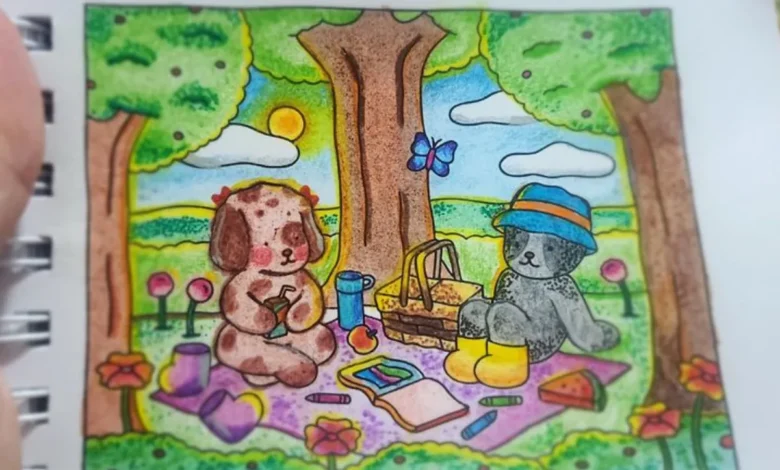 Esta imagem representa dois personagens Bobbie Goods curtindo um piquenique sob o sol em um cenário colorido com árvores, flores, caderno de desenho e lápis espalhados. O céu ao fundo está iluminado e vibrante, transmitindo a sensação de um dia calmo e feliz. Ideal para ilustrar conteúdos sobre pintura emocional com lápis de cor e cenas ao ar livre.