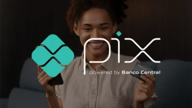 Mulher sorrindo enquanto segura um smartphone e um cartão de crédito, destacando o uso do PIX como solução de pagamento.