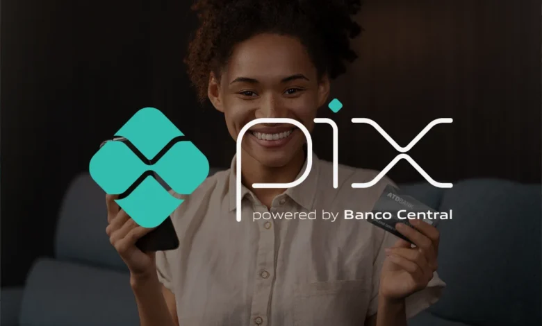 Mulher sorrindo enquanto segura um smartphone e um cartão de crédito, destacando o uso do PIX como solução de pagamento.