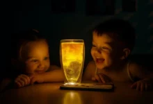 Crianças observando o efeito iluminado de um copo, parte do viral do Pozinho Mágico.