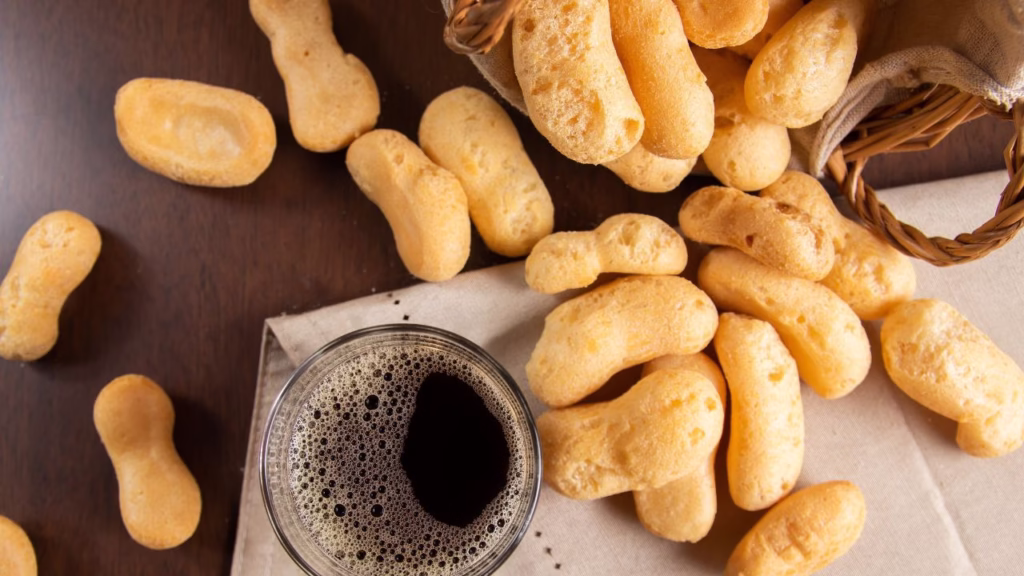 Biscoitos de polvilho frescos com uma bebida ao lado.