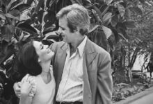 Casal sorridente em cena romântica de novela clássica da TV Globo.