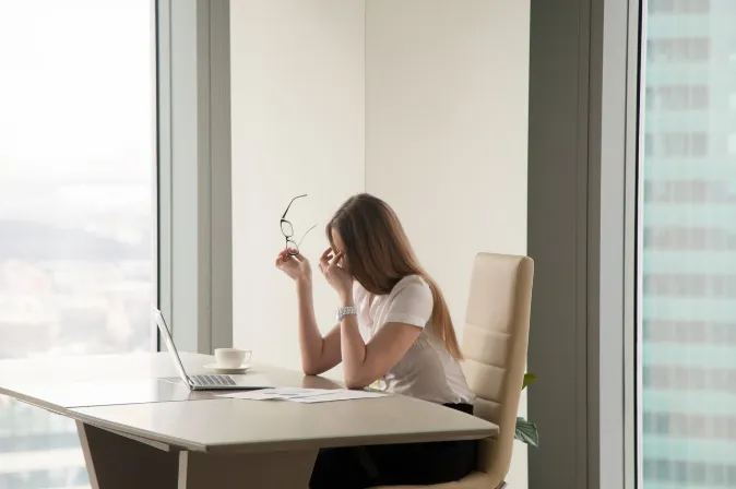 Mulher com estresse no trabalho, procurando um momento de pausa para cuidar da saúde mental