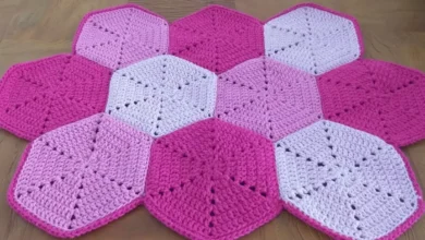 Tapete de crochê hexagonal em tons de rosa e lilás, formando um padrão geométrico