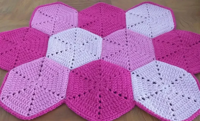 Tapete de crochê hexagonal em tons de rosa e lilás, formando um padrão geométrico
