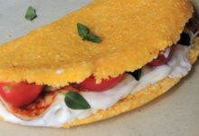 Tapioca de cuscuz recheada com frango, tomate, queijo cremoso e folhas de manjericão